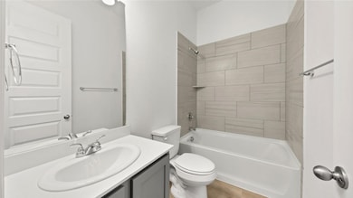 Full bathroom with bathing tub / shower combination, vanity, and light wood-style floors