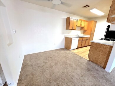 Kitchen with dishwasher, light colored carpet, a s