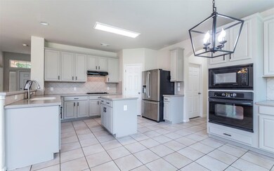 Kitchen with black appliances, a sink, under cabi