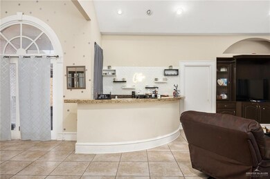 Kitchen featuring light stone countertops, tasteful backsplash, and light tile flooring