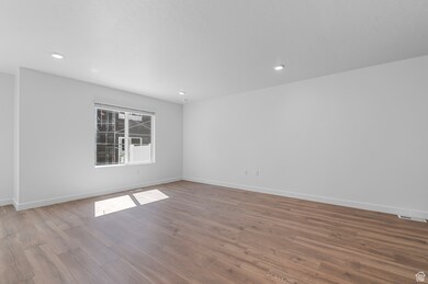 Empty room with wood finished floors and recessed lighting