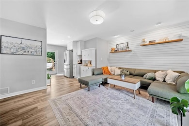 Living area with tons of natural light, wood-style floors, recessed lighting, and entrance mudroom.