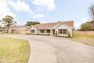 Ranch-style home featuring curved driveway and roo