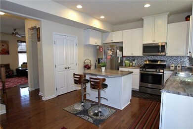 The kitchen features white cabinets, stainless app