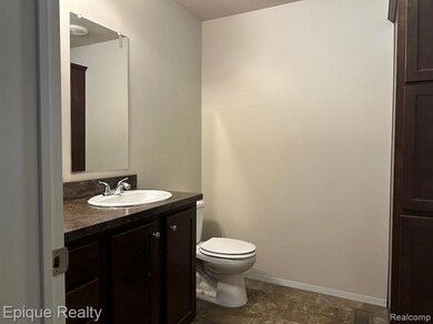 Half bathroom with vanity and dark stone finish floors