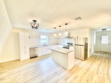 Kitchen with wall chimney range hood, appliances 