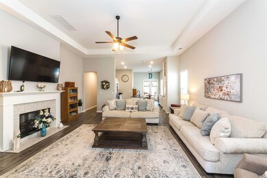 Living room with a tile fireplace, a tray ceiling,
