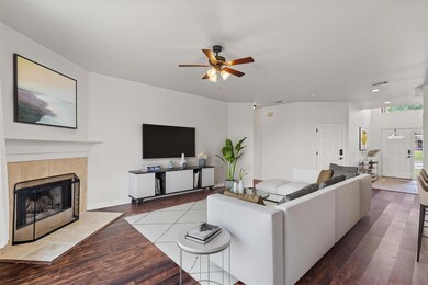 Living room featuring a ceiling fan, wood finishe