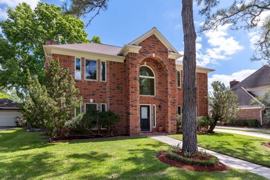 Well manicured front lawn with mature trees greet