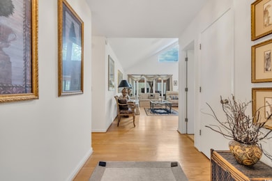 Hallway featuring light wood-type flooring, basebo