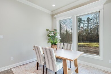 Dining room with crown molding and light hardwood 