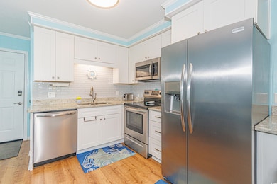 Kitchen featuring crown molding, stainless steel a