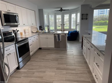 Kitchen with a ceiling fan, a peninsula, appliance