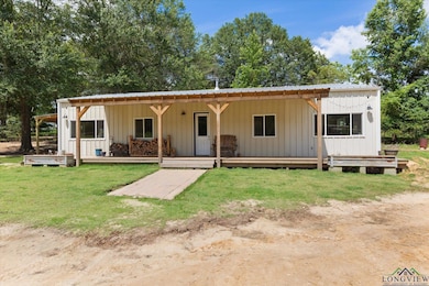 View of front of house with board and batten siding, a front yard, and a metal roof