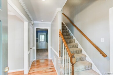 Foyer with Hardwood and crown molding.