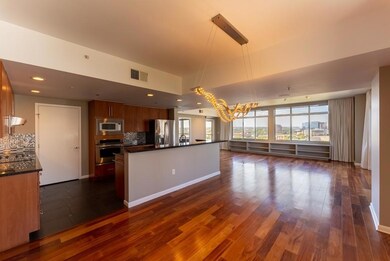 Kitchen featuring dark countertops, open floor plan, dark wood-type flooring, stainless steel appliances, and recessed lighting