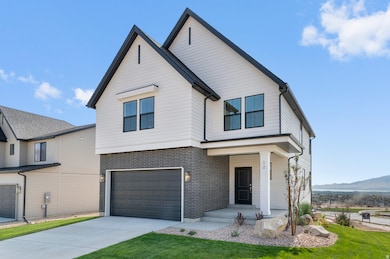 View of front of property featuring a porch, driveway, a garage, brick siding, and a front yard
