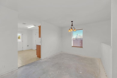 Empty room with unfinished concrete floors and a 