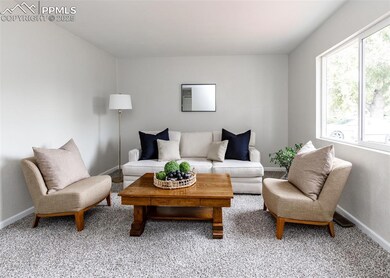 Carpeted living room featuring baseboards