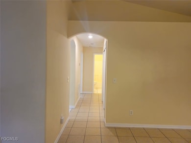 Corridor with light tile patterned floors and arched walkways