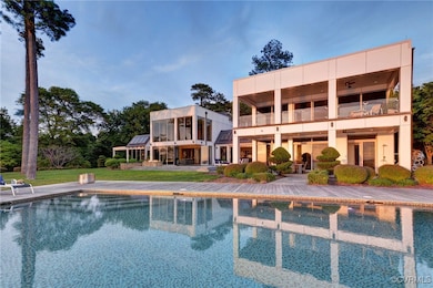Rear view of house with an outdoor pool, a balcony