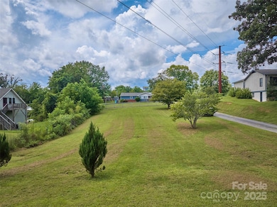 Cleared gentle lot with view of photo facing from Moody Ave towards lot.  Future driveway would be on left side of photo and shared with Lot C
