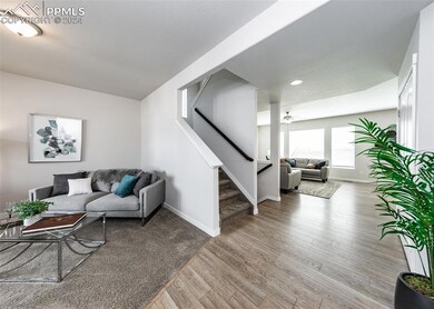Living room featuring ceiling fan and hardwood / w