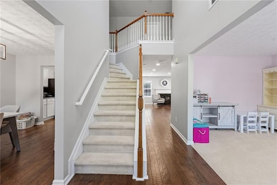 Staircase with a towering ceiling, baseboards, a t