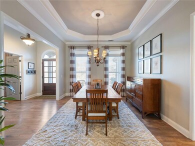 Dining area with wood-type flooring, crown molding