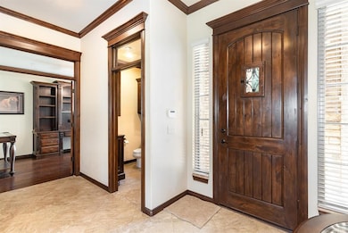 Entrance foyer with ornamental molding and baseboards
