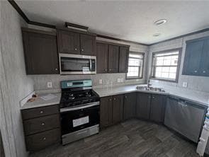 Kitchen with appliances with stainless steel finishes, dark wood-style floors, and light countertops