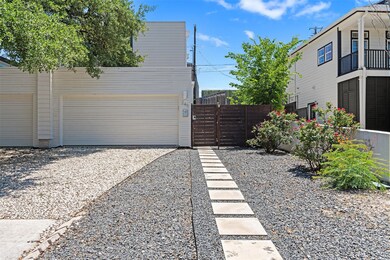 Garage featuring fence, driveway, and a gate