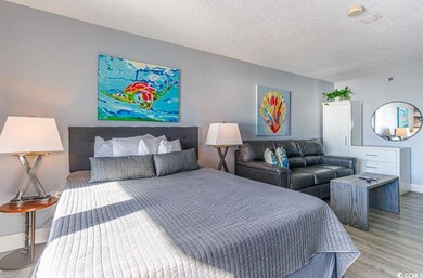 Bedroom with a textured ceiling and light hardwood