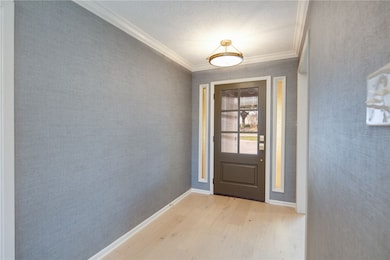 Entryway with ornamental molding, light wood-style