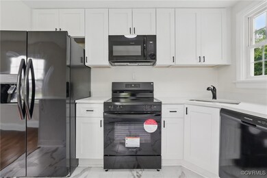 Kitchen featuring black appliances, light marble f