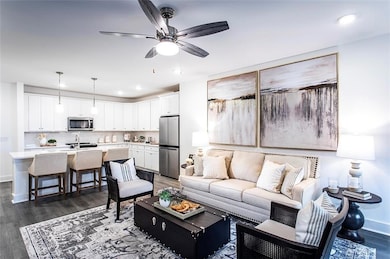 Living area with dark wood-style floors, ceiling fan, recessed lighting, and baseboards