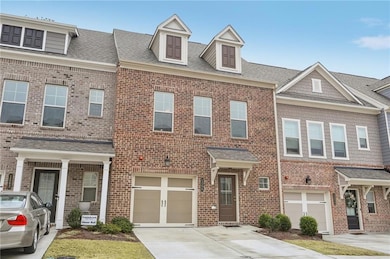 Brick front townhouse featuring a garage, a shingl