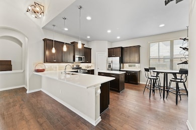 This modern kitchen features dark wood cabinets, s