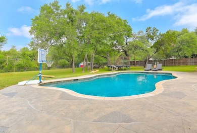 View of pool featuring a patio and view of wooded
