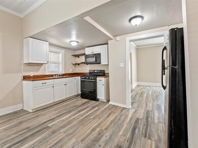 Kitchen featuring open shelves, black appliances, 