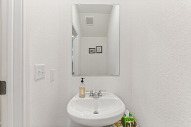 Bathroom featuring a textured wall and a sink