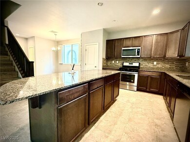 Kitchen featuring light stone counters, a center i
