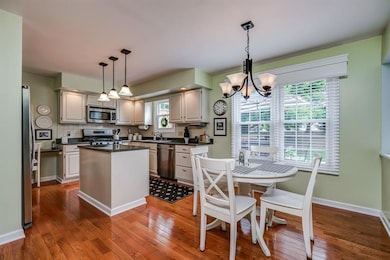 Updated modern light fixtures and beautiful wood box window treatments are perfect accents to this light and delightful kitchen!