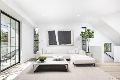 Living room featuring light wood-type flooring, recessed lighting, and lofted ceiling