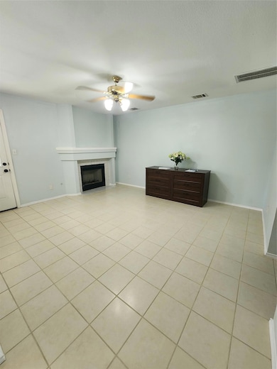 Living area with ceiling fan, light tile patterne
