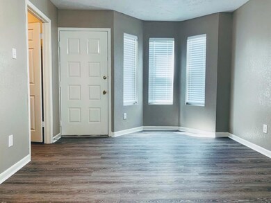 Entrance foyer with a textured wall, baseboards, a