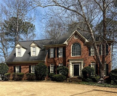 View of front facade with brick siding, a front ya