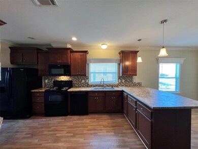 Kitchen featuring black appliances, a peninsula, 
