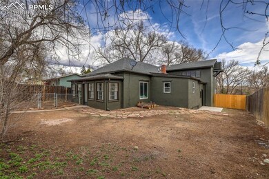 Rear view of property with a gate, a chimney, stuc