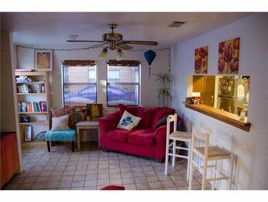 Living room featuring a ceiling fan and tile patt